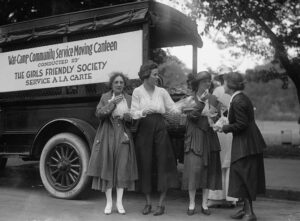 Black and white photo of women buying lunch from a food truck, 1909.