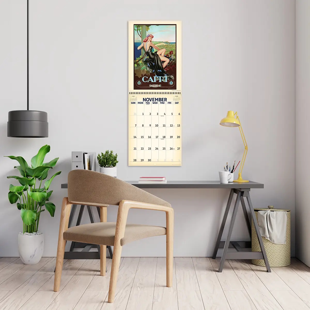 2027 Retro Pinups in Paradise Deluxe Calendar hanging above a desk