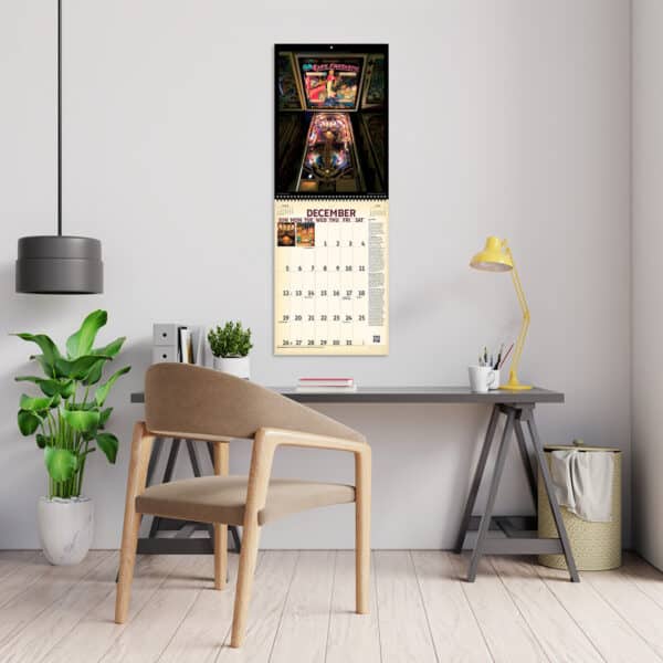 2027 Vintage Pinball Deluxe Calendar hanging above a desk