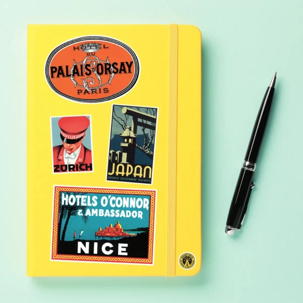 A sampling of stickers from the Vintage Luggage Labels sticker set stuck on a notebook